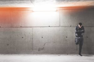 Young Man Standing In Front of Concrete Wall