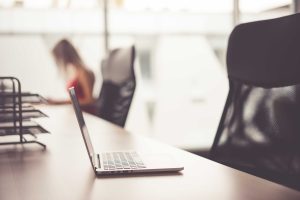 Laptop on Wooden Desk in Office Open Space