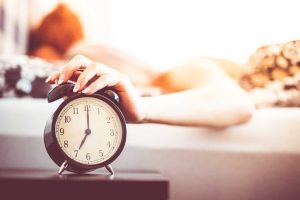 Woman Shutting Off Ringing Alarm Clock